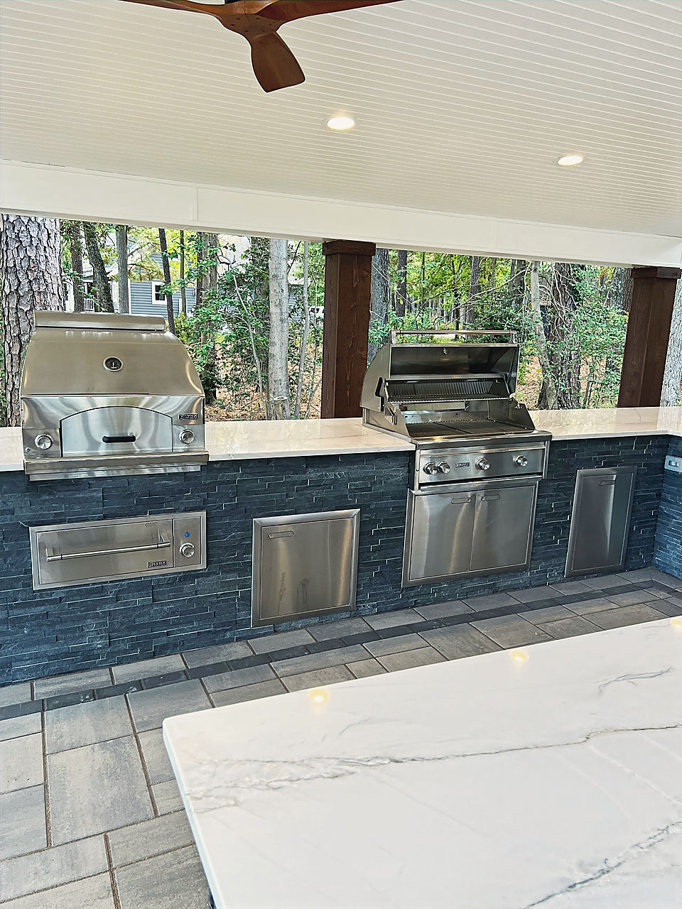 Two built in grills in a stacked stone base