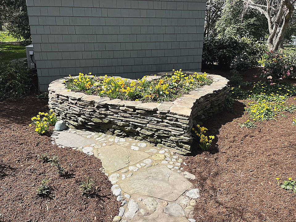 A dry stacked stone bed, newly planted