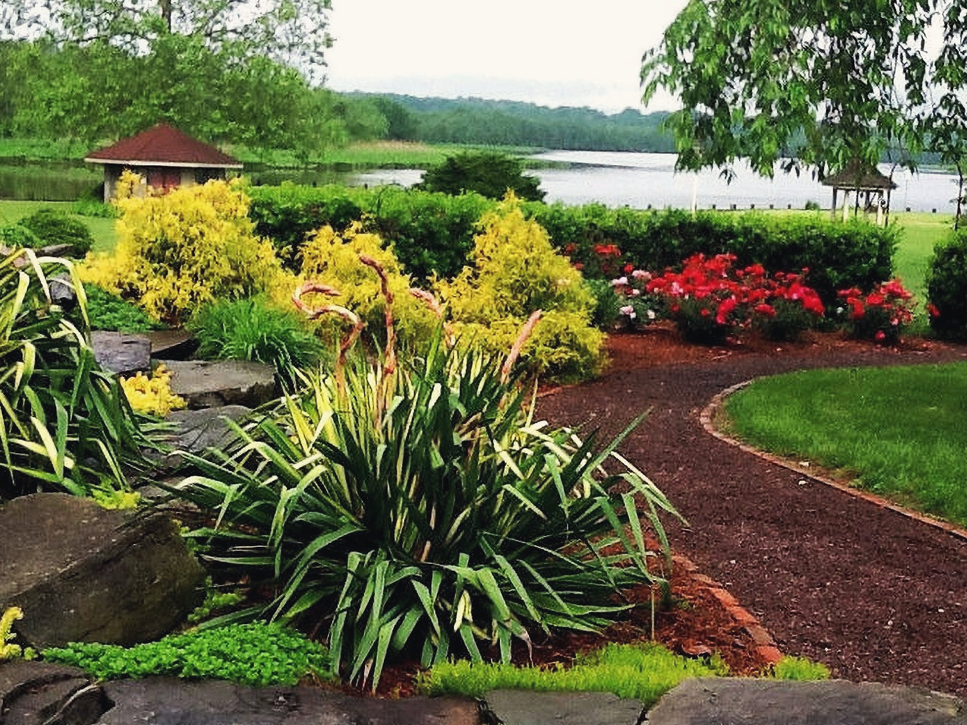 A stone edged bed and a mulch path above the river