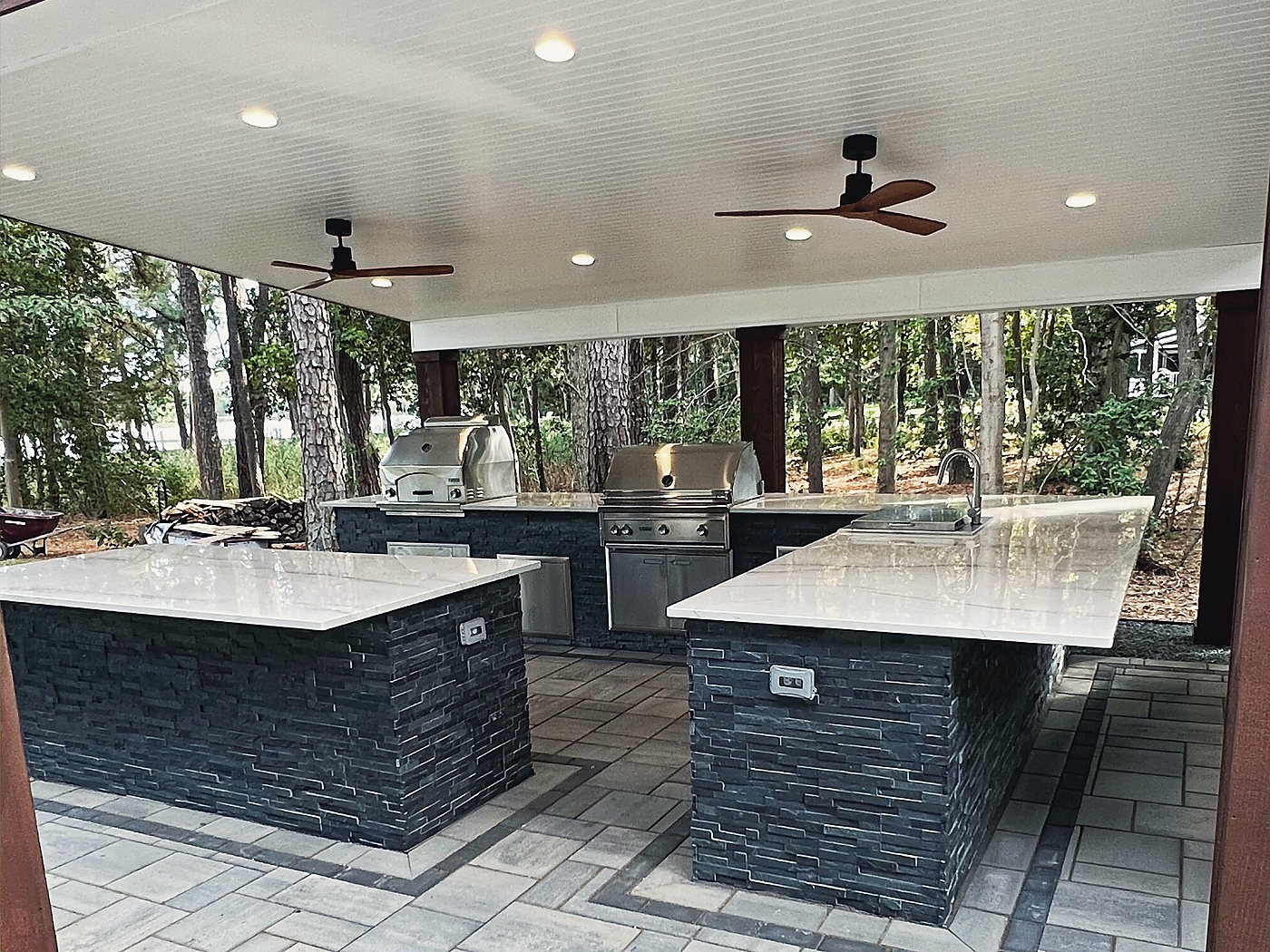 Stone counters on stacked stone islands under a lit timber roof