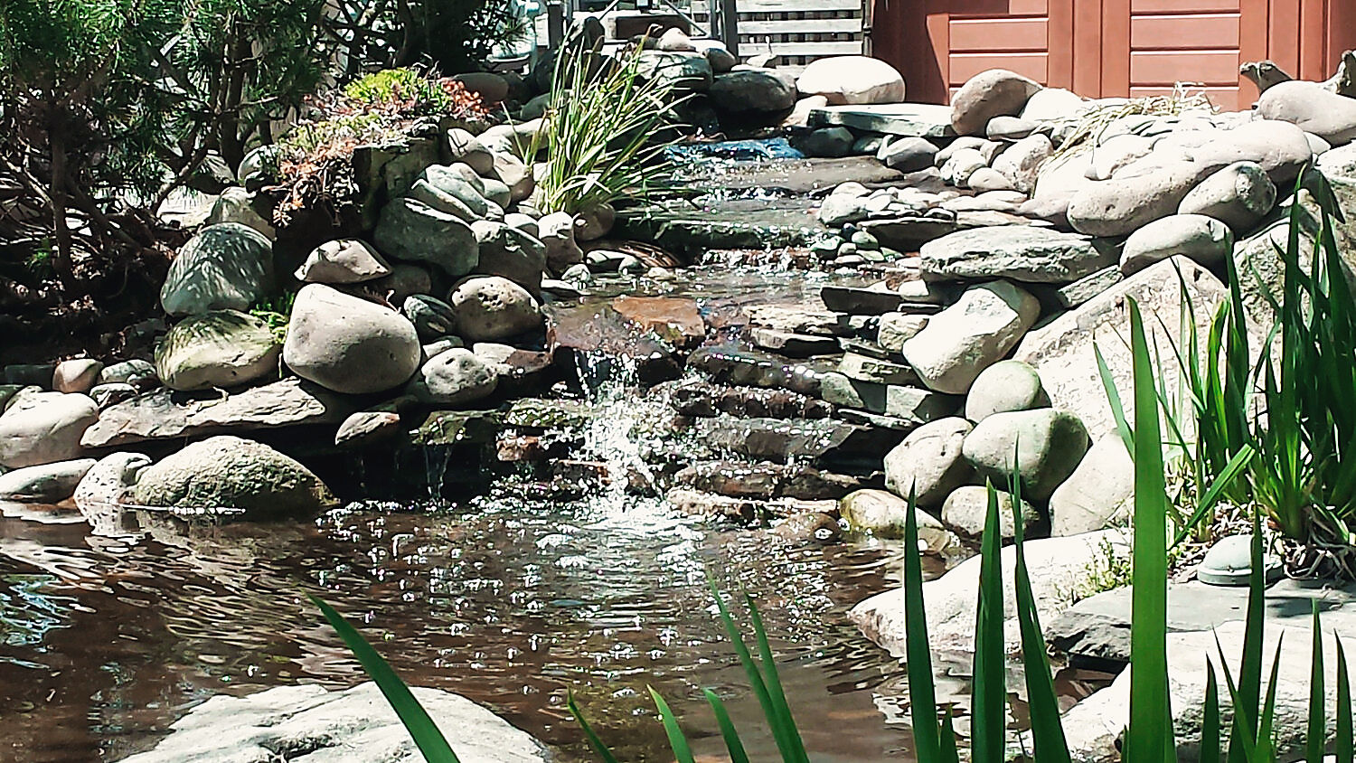 Falls stepping down through river stone into a pond